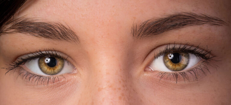 Zbliżenie na oczy osoby z naturalnymi rzęsami i brwiami, ilustrujące problem wypadania włosów w tych okolicach